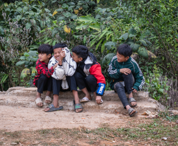 Vietnamesische Jungen sitzen draußen.