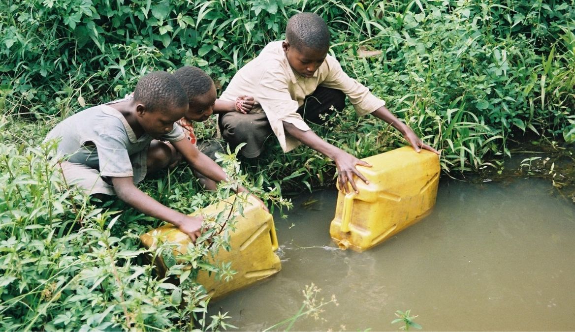 Verschmutztes Wasser wird aus Teich in Kanister umgefüllt